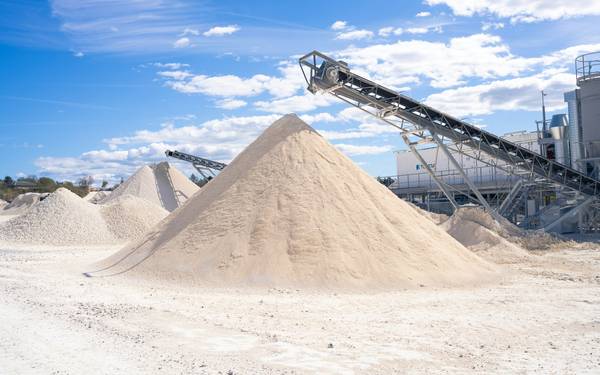 Sand stockpiles beside conveyors at a sand and gravel processing site — stock photo